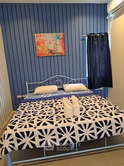 Cozy bedroom with stylish blue decor and modern art, perfect for relaxation.