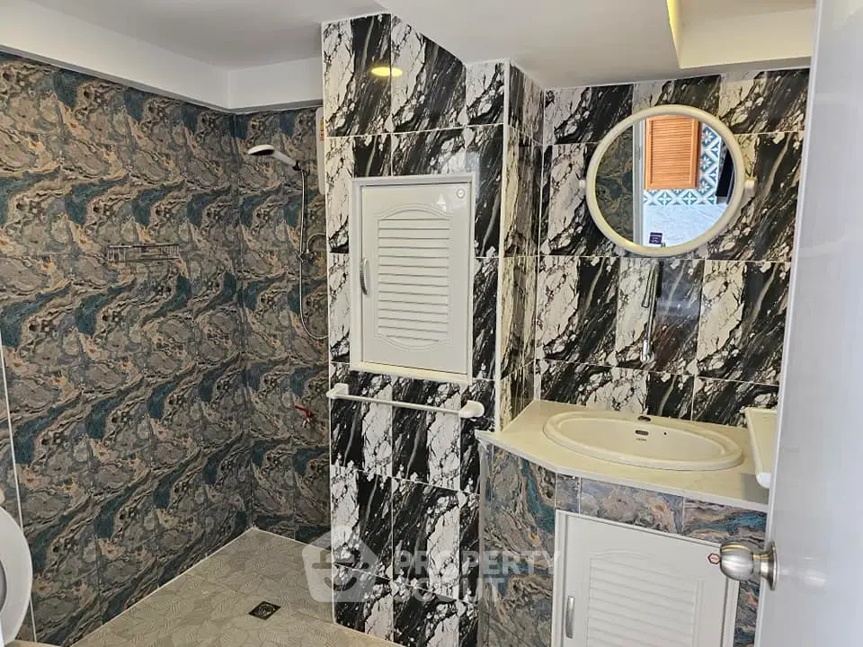 Stylish bathroom with unique marble-patterned walls and modern fixtures