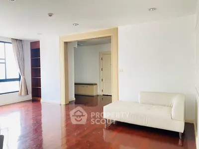 Spacious living room with hardwood floors and modern white sofa