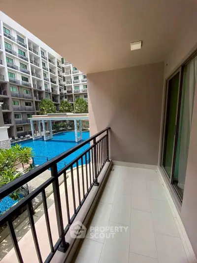 Spacious balcony with pool view in modern apartment complex