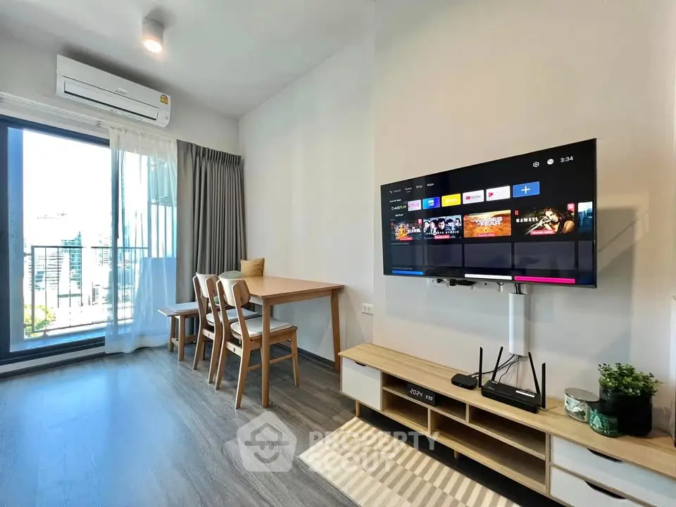 Modern living room with sleek TV setup and balcony view in stylish apartment.