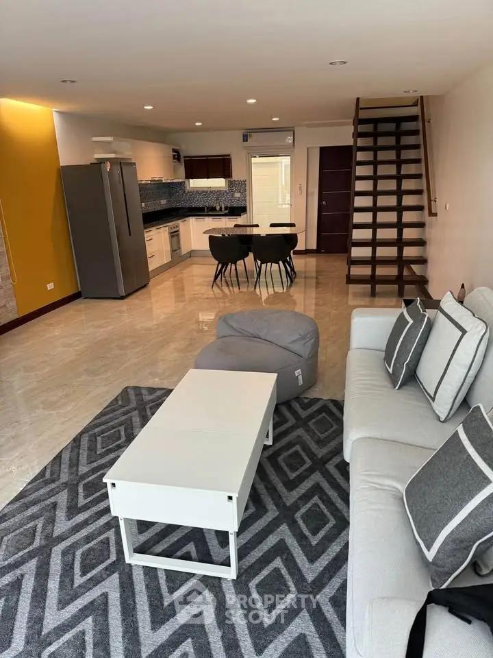 Spacious modern living room with open kitchen and stylish staircase