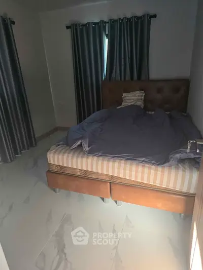 Cozy bedroom with elegant curtains and a comfortable bed, perfect for restful nights.