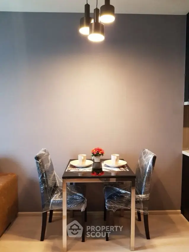 Modern dining area with stylish lighting and elegant table setting in a cozy apartment.