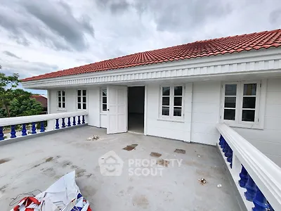 Spacious balcony with white railing and red roof, perfect for outdoor relaxation.