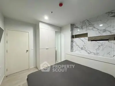 Modern bedroom with marble accent wall and sleek storage solutions