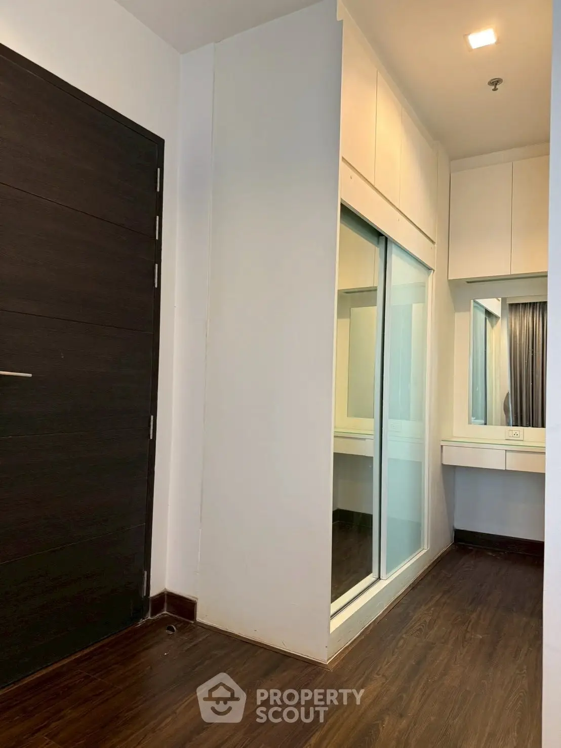 Modern hallway with sleek wooden flooring and built-in storage