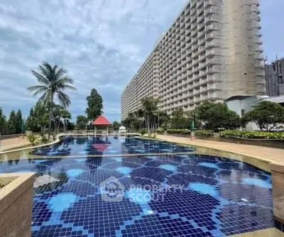 Luxurious residential building with stunning pool and lush landscaping.