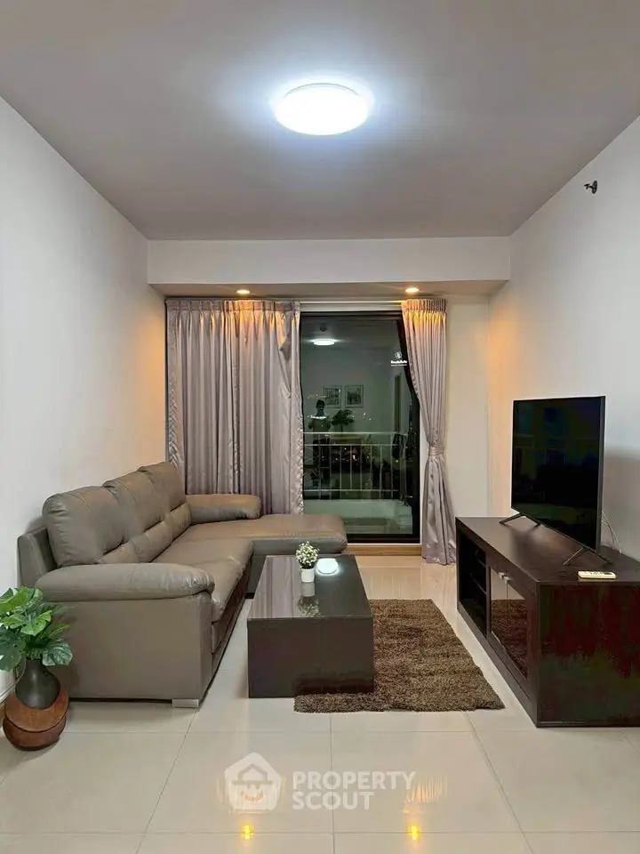 Modern living room with sleek furniture and large window offering natural light.