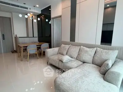 Modern living room with stylish sofa and dining area in open layout apartment.