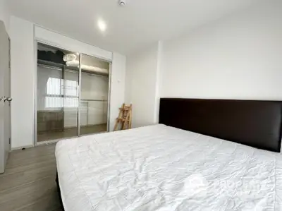 Spacious modern bedroom with minimalist design and large mirrored closet