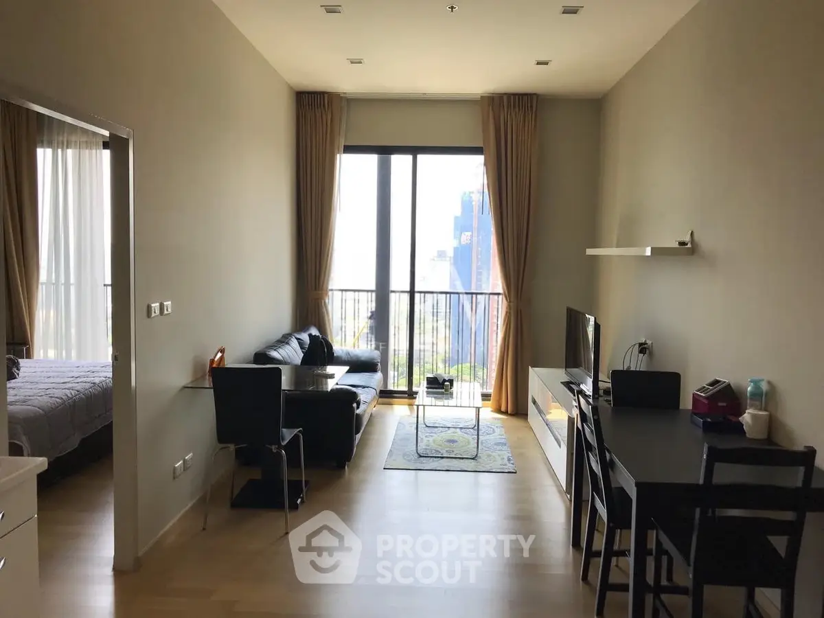 Modern living room with large windows and city view, featuring stylish furniture and open layout.