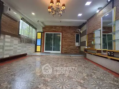 Spacious living room with elegant chandelier and large windows for natural light.