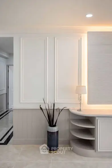 Elegant interior with modern decor and ambient lighting, featuring a stylish lamp and decorative vase.