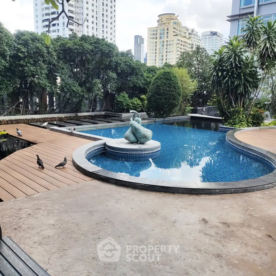 Luxurious outdoor pool area with modern sculpture and lush greenery in urban setting.