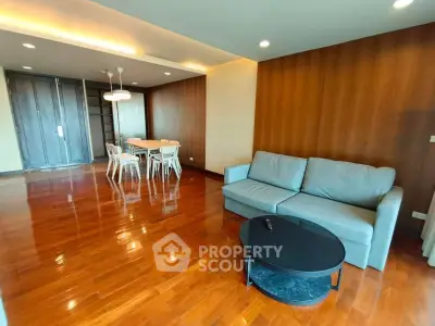 Spacious living room with wooden flooring and modern furniture in a stylish apartment.