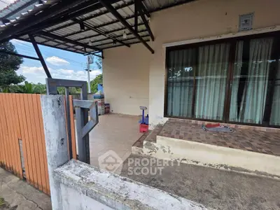 Charming exterior view of a cozy home with tiled patio and large glass doors, perfect for relaxation.