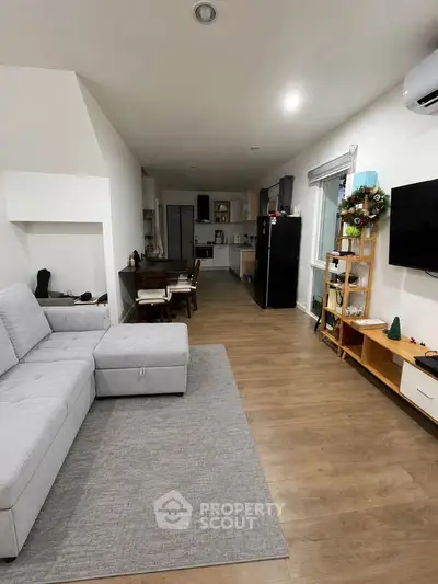Spacious living room with modern decor and open kitchen layout, perfect for family gatherings.