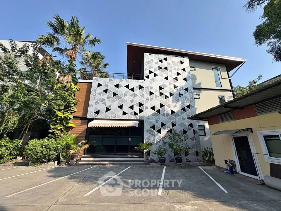 Modern building exterior with geometric facade and lush greenery