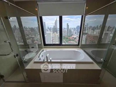 Luxurious bathroom with stunning city skyline view from large window.