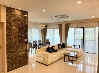 Luxurious open-plan living room with elegant decor and large windows offering natural light.