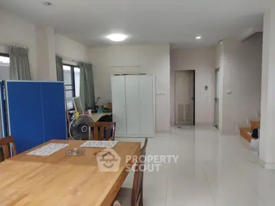 Spacious open-plan living area with dining table and storage cabinets