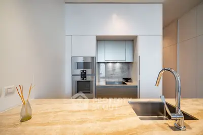 Modern kitchen with sleek design, featuring built-in appliances and elegant marble countertop.