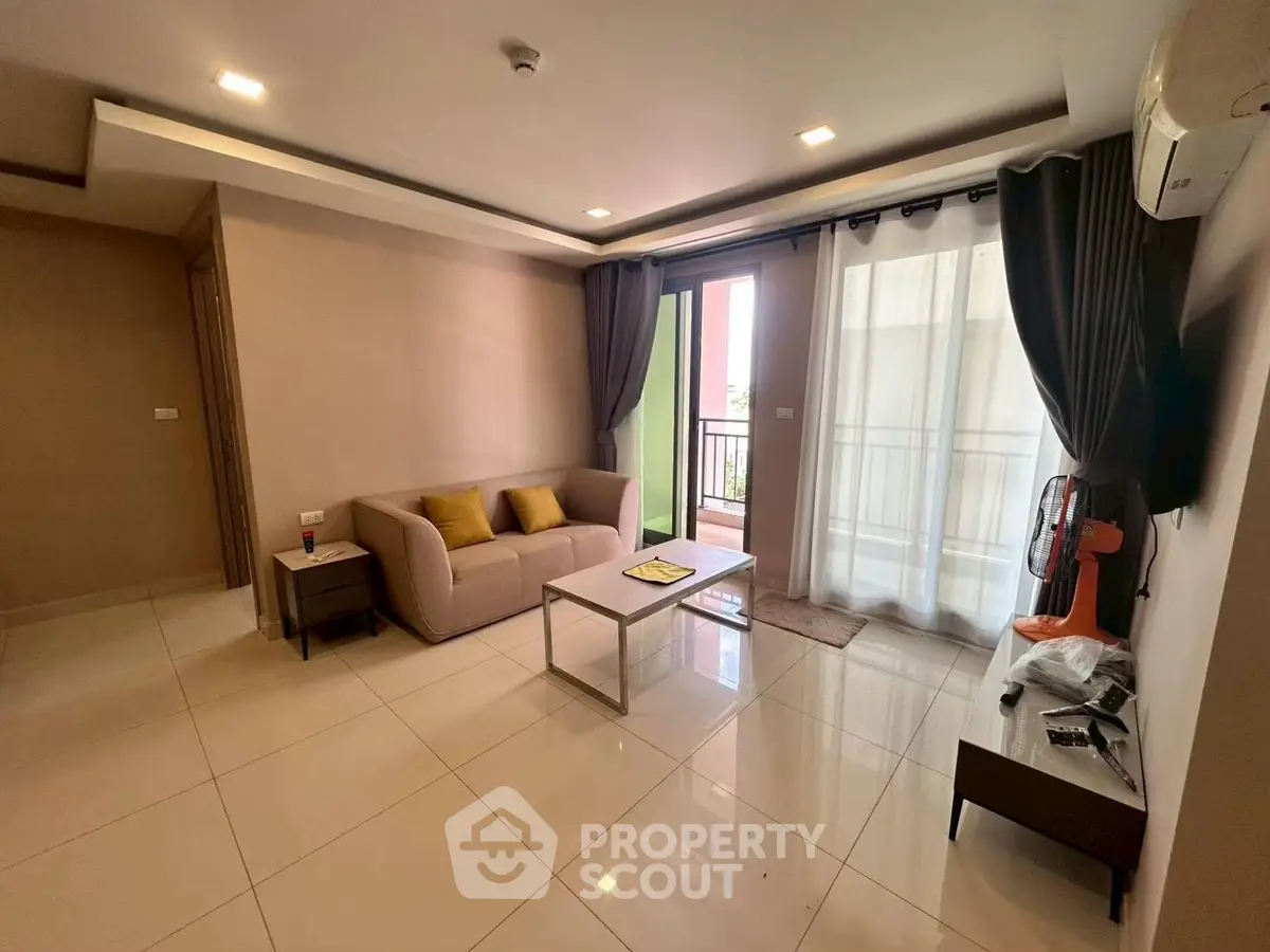 Spacious living room with modern decor and balcony access