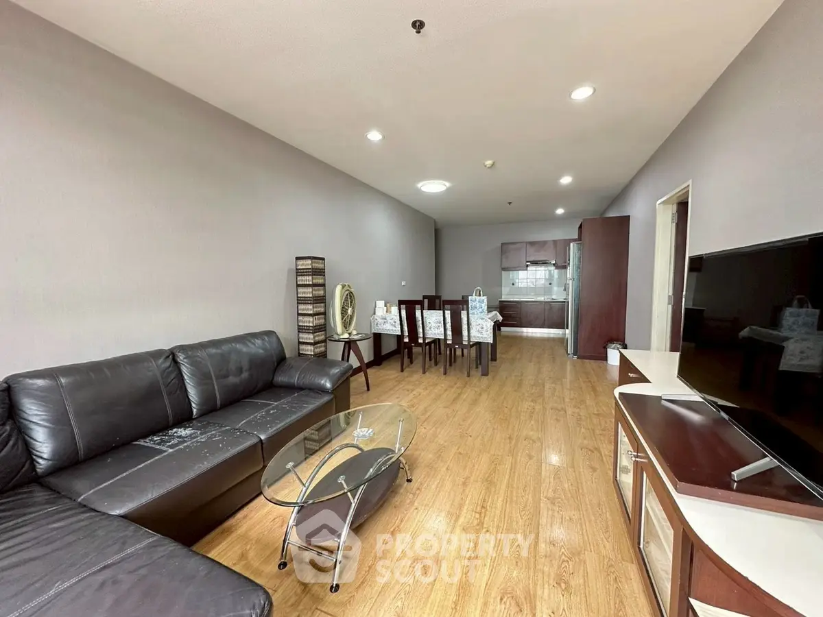 Spacious living room with modern furniture and open kitchen layout.