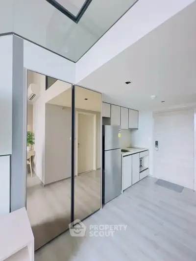 Modern kitchen with sleek design and stainless steel appliances in a bright apartment.