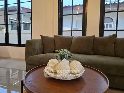 Stylish living room with cozy green sofa and elegant decor