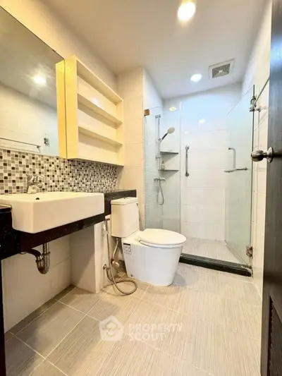 Modern bathroom with glass shower and stylish tile accents.