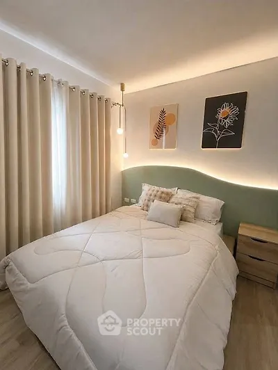 Cozy bedroom with modern decor and soft lighting, featuring a comfortable bed and stylish artwork.