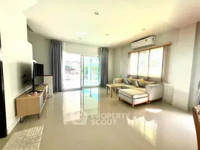 Spacious modern living room with sleek furniture and large windows for natural light.