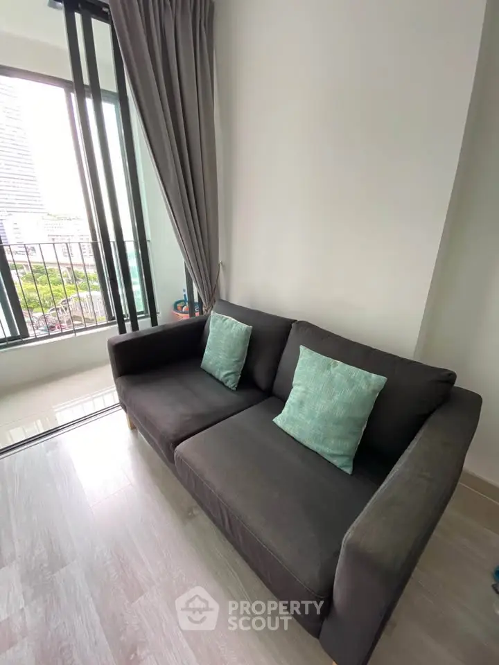 Modern living room with cozy sofa and large window offering city view