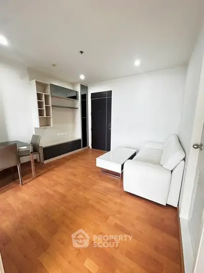 Modern living room with wooden flooring and white sofa in a cozy apartment.