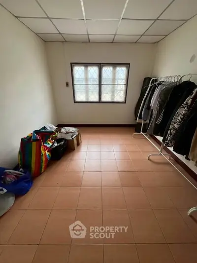 Spacious room with tiled floor and window, ideal for storage or conversion into a cozy living space.
