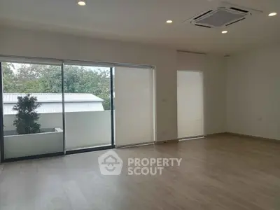 Spacious modern living room with large windows and wooden flooring