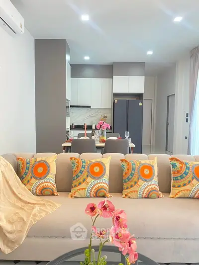 Modern living room with vibrant decor and open kitchen layout