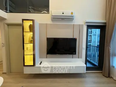 Modern living room with wall-mounted TV and air conditioning unit, featuring sleek storage and balcony view.