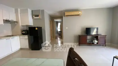 Modern living room with kitchen, featuring sleek appliances and stylish decor.