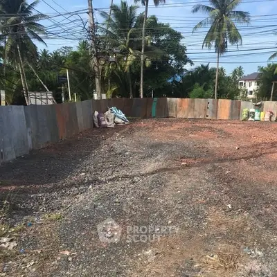 Vacant land plot surrounded by trees, ideal for development in a tropical setting.