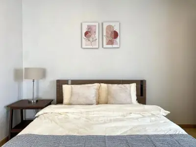 Cozy bedroom with modern decor and stylish artwork above the bed.