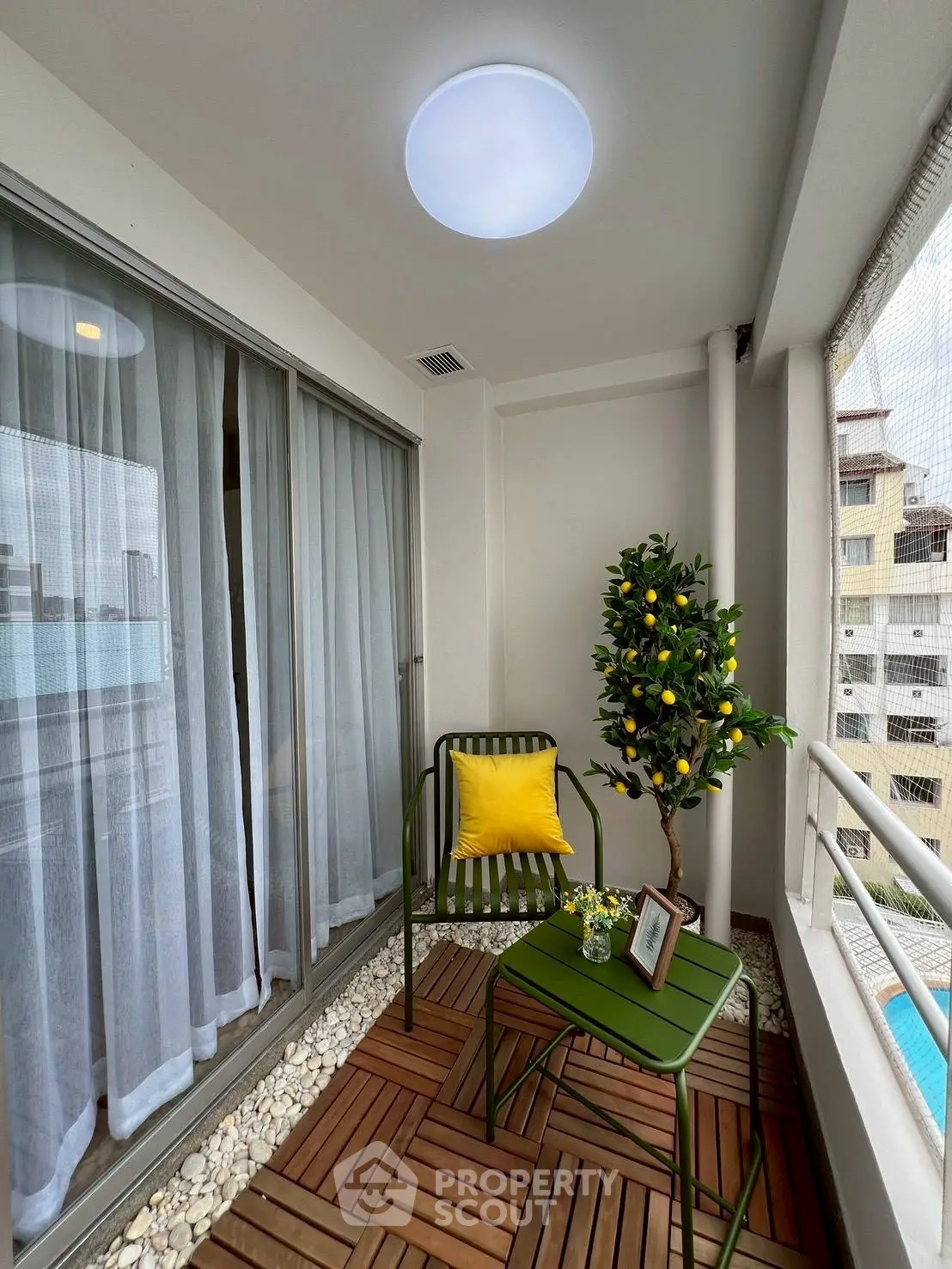 Charming balcony with cozy seating and decorative plant, perfect for relaxation.