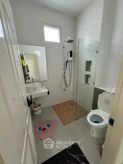 Modern bathroom with shower, toilet, and sink in compact layout