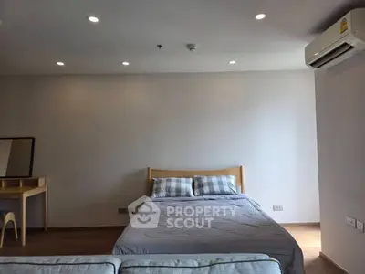 Modern bedroom with cozy bed and air conditioning in a minimalist design apartment.