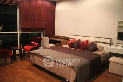 Luxurious bedroom with elegant decor and hardwood flooring in modern apartment.