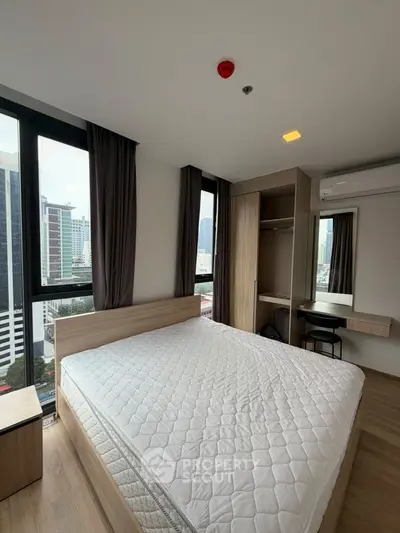 Modern bedroom with city view, featuring a large bed and built-in wardrobe in a high-rise apartment.