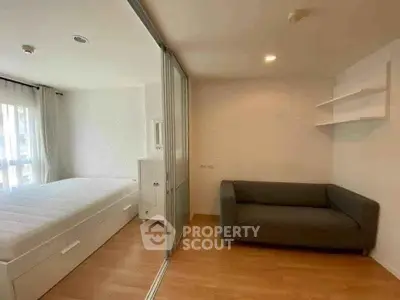 Modern bedroom with sliding glass partition and cozy living area