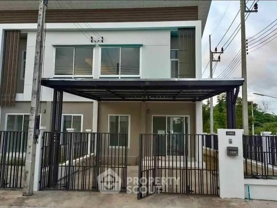 Modern townhouse with sleek design and gated entrance in a suburban neighborhood.